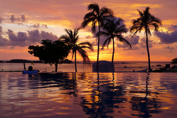 Fototapeta na wymiar Tropical paradise sunset reflecting on a swimming pool and sandy beach in Punta Mita, Mexico