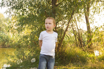 Cheerful and naughty boy playing in nature