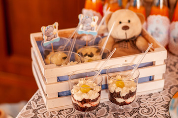 cake with cream and chocolate in the cup and teddy bear on the back