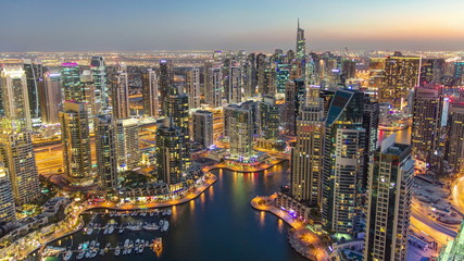 Dubai Marina with modern towers from top of skyscraper transition from day to night timelapse