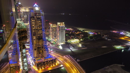 Fototapeta na wymiar Night view on hotels and bridge with traffic timelapse at Dubai Marina