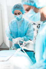 Waist up portrait of female medical worker in protective mask and sterile gloves providing...