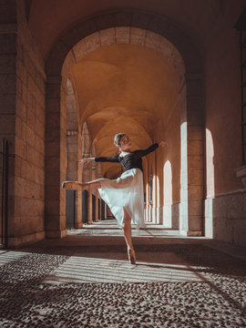 Portrait of young ballerina dancing in archway
