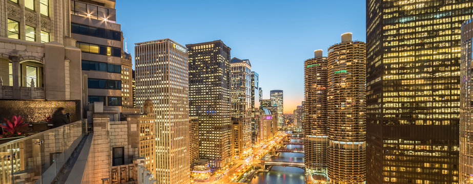 Panoramic illuminated waterfront skyscrapers along Chicago river at blue hour