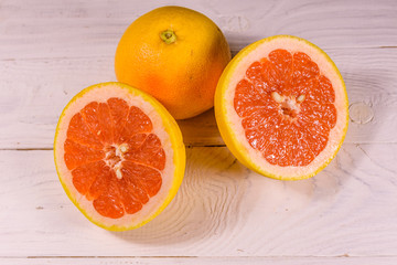 Ripe juicy grapefruit on a white wooden table