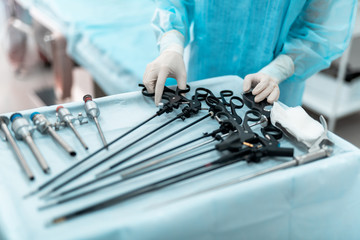 Tools for surgery. Close up of female hand holding laparoscopic scissors or grasper