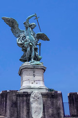 Fototapeta na wymiar Bronze sculpture of the Archangel Michael mounted on the roof of Saint Angel Castle. Castel Sant'Angelo, Rome