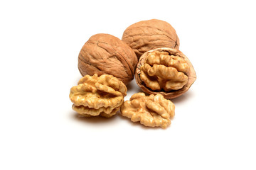 Walnut and kernels, two whole walnuts and three kernels, close-up macro, isolated on a white background.