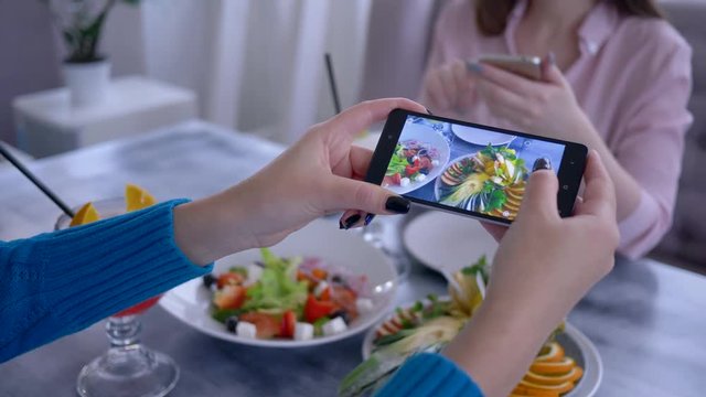 food photo, arm of girl using mobile phone for pictures of vegetarian meal during healthy breakfast for social media in restaurant, close-up