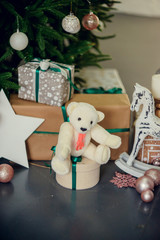 gifts under the Christmas tree, toy bear and boxes, the concept of a cozy home new year