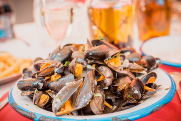 Sea mussels in a deep plate and white wine - restaurant
