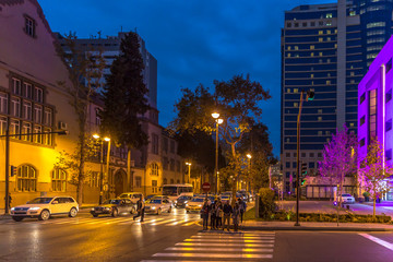 Baku, Azerbaijan - Oct 11th 2018 - Locals and tourists crossing a road at night in Baku in Azerbaijan