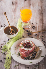 Whole camembert wrapped in dry ham with cranberries on top