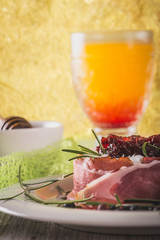 Whole camembert wrapped in dry ham with cranberries on top