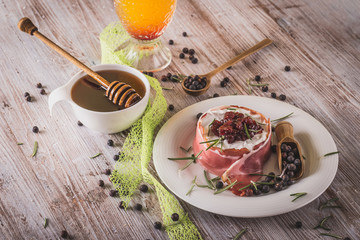 Whole camembert wrapped in dry ham with cranberries on top