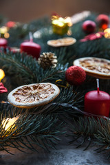 Christmas card with spruce and citrus, as well as red candles and decorations