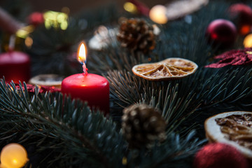 Christmas background with fir and citrus, as well as red candles and decorations