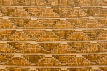 Close up shot of the amazing architecture of the patterned stairs at Abhaneri baori stepwell in Jaipur Rajasthan. This landmark is a water storage well and is now a protected monument