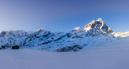 Landscape panoramic of the Matterhorn mountain with snow and a blue sky