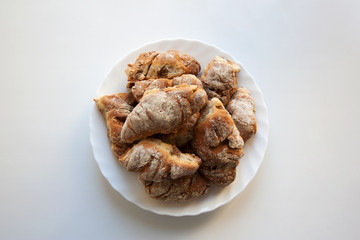 Freshly baked croissants on plate isolated on white background from a high angle view