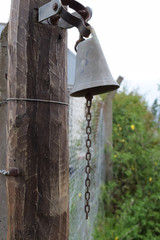 antique bell at the entrance to the ranch near the roads