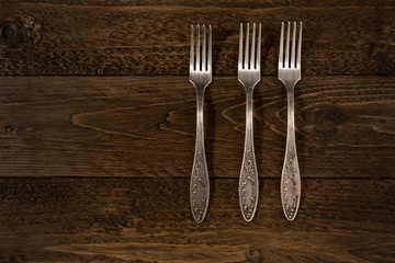 Set of vintage forks on a wooden background
