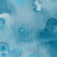Blue watercolor winter texture with abstract washes and brush strokes on the white paper background.