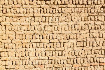 Ancient islamic Arabic muslim old town house wall built of yellow brown mud bricks texture. Al Qasr, Dakhla Oasis, Western Desert, Egypt, Africa.