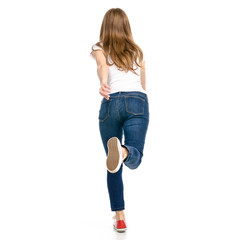 Woman in jeans and t-shirt runs goes on white background isolation back view