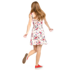 Fototapeta premium Beautiful woman in dress with flowers print and sneakers showing of positive emotions goes happy back view on white background isolation