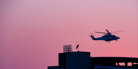 Air ambulance helicopter departing from a hospital helipad.