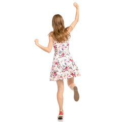Beautiful woman in dress with flowers print and sneakers showing of positive emotions runs happy  back view on white background isolation