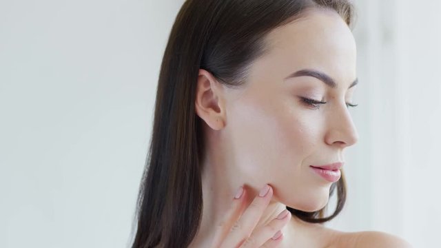 Confident beautiful lady smirking and looking at camera while standing on white background
