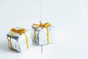 Silver colored gift box on white wood