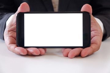 Businessman holding smartphone forward empty white screen for your text or picture.