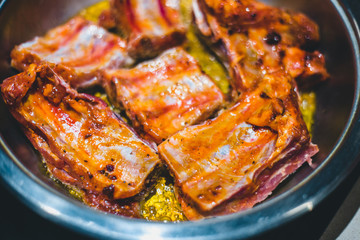 Spicy marinated pork ribs are fried in a pan