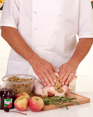 CHEF FILLING CHICKEN WITH BREAD AND FRUIT STUFFING