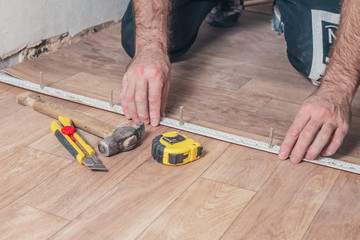 Minsk, Belarus - November 12, 2018: Installation of self-adhesive plastic floor threshold sill by...