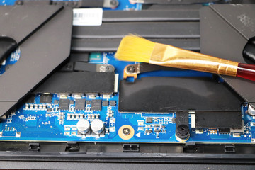 A geek cleans a laptop cooler. Contaminated computer cooling system. Technical support concept