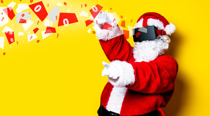 Funny Santa Claus have a joy with VR glasses on yellow background