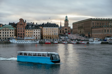 Cityscape of Gamla Stan in Stockholm, Sweden, at sunset. Pleasure boat of blue color