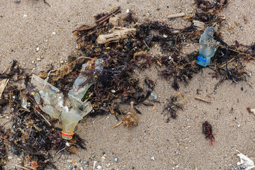 Empty used dirty plastic bottles on the beach. Environmental pollution at the beach