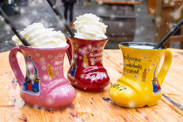 Christmas beverage - Eggnog, also known as milk punch or egg milk punch, in cup in the form of shoe with German text, translated as - Aachen Christmas Market Hexenhof (restaurant), Aachen, Germany