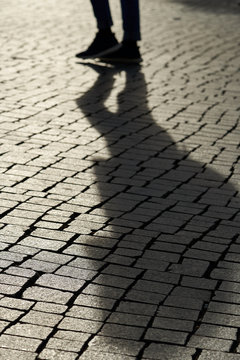 Schatten eines Fußgängers in der Innenstadt von Leipzig im Gegenlicht