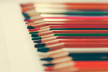 Back to school, concept from colored pencils on a yellow background from textured paper for sketching. Tinted in a trendy and modern style with a touch of noise added. Preparation for creativity