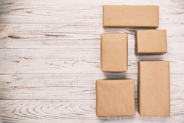 cardboard box on white wooden background, vintage, toned Brown mail package top view
