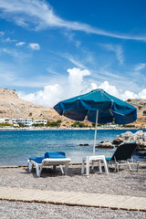Sonnenschirm und Liegen am Meer