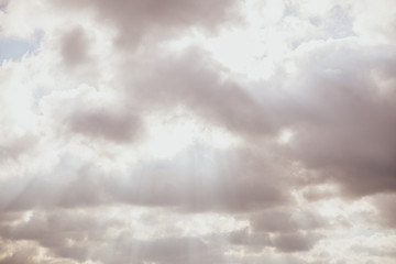 Obraz premium Sun hiding behind the fluffy clouds. Sunlight coming through clouds