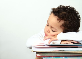 little boy sleeping on a pile of books
