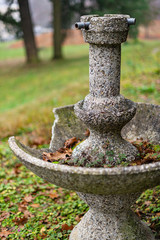 broken stone fountain empty without water in autumn park